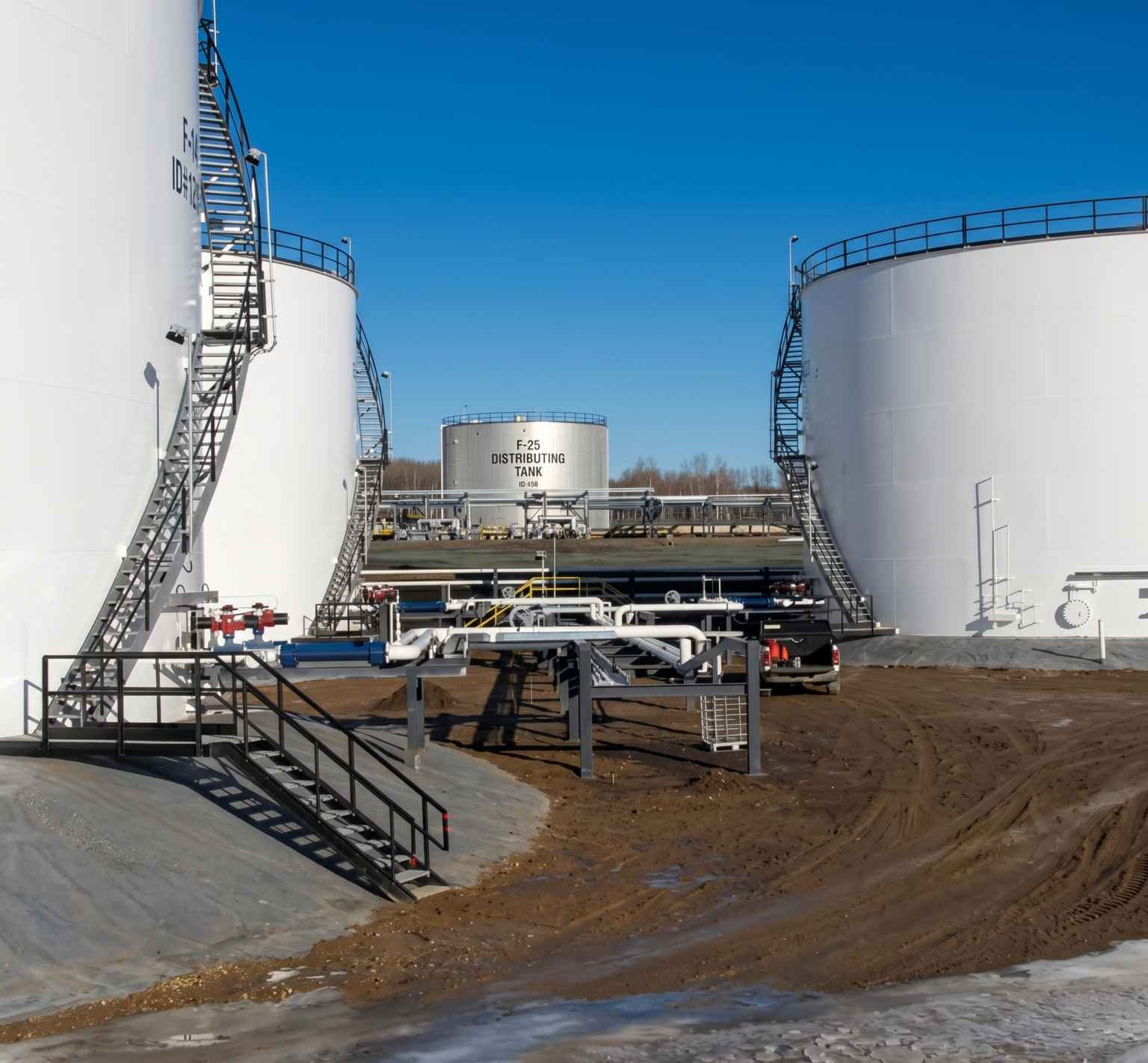 Petroleum loading equipment operating beside large storage tanks